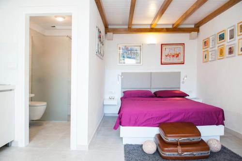 a bedroom with a pink bed and a bathroom at House Koloc in Bol