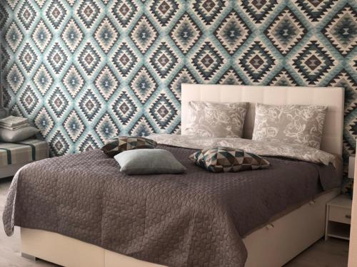 1 dormitorio con 1 cama con pared azul en Vanilla Sky Apartments, en Sillamäe