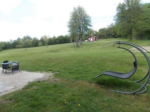 einen Park mit einer Bank und einer Skulptur im Gras in der Unterkunft Les Gîtes De Morville in Malaumont
