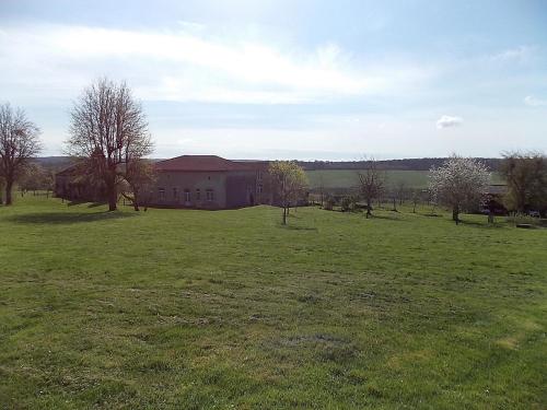ein leeres Feld vor einem großen Gebäude in der Unterkunft Les Gîtes De Morville in Malaumont