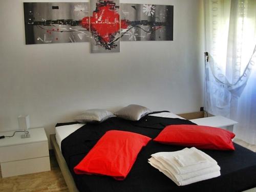 a bedroom with a bed with red and black sheets at Villa Harriet in Sovere