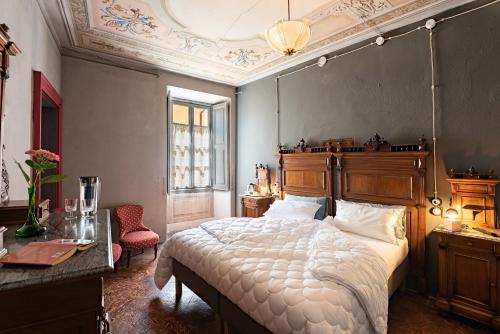 a bedroom with a large bed with a wooden headboard at B&B Villa Rosalinda in Dongo