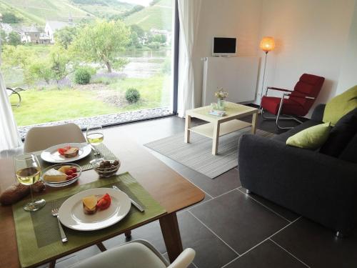 a living room with a table with a plate of food at Ferienwohnung Moselufer Zell in Zell an der Mosel