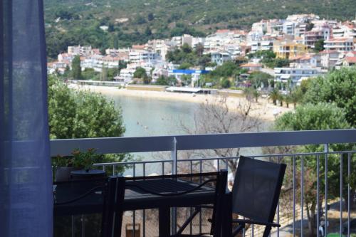 a balcony with a table and a view of a beach at Beach Side Apart II in Kavala