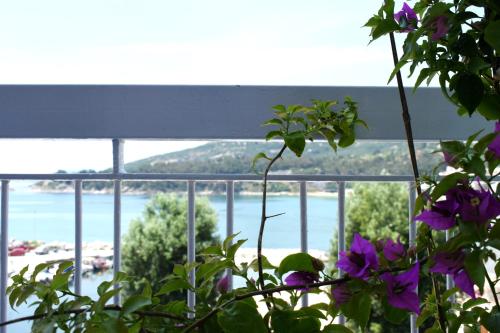 a view of the ocean from a balcony with purple flowers at Beach Side Apart II in Kavala
