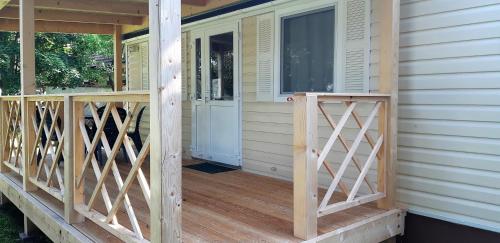a front porch of a house with a wooden deck at Mobile Homes and Apartment - Terme Čatež in Čatež ob Savi
