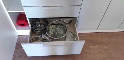 a white kitchen with two pots and pans in a drawer at Mobile Homes and Apartment - Terme Čatež in Čatež ob Savi