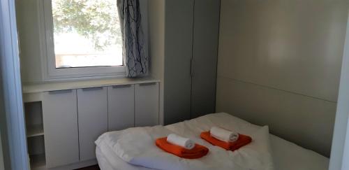a bedroom with two towels on a bed with a window at Mobile Homes and Apartment - Terme Čatež in Čatež ob Savi