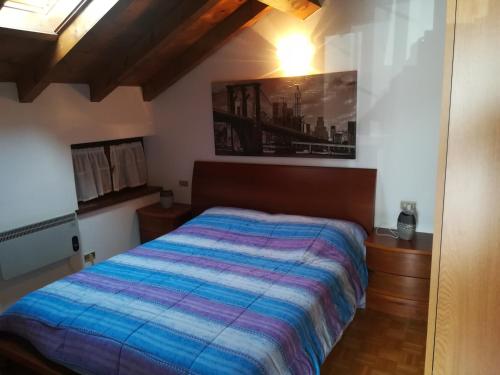 a bedroom with a bed with a colorful blanket at Condominio La Rasica in San Martino di Castrozza