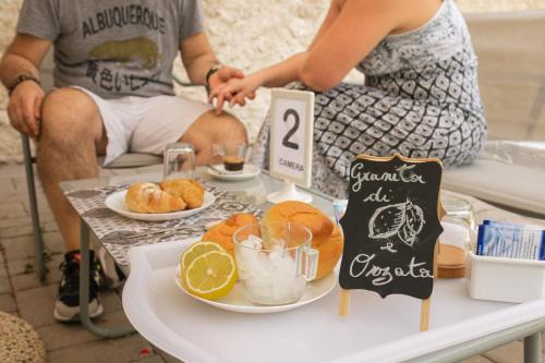 a group of people sitting at a table with food at Al Qatta Bed & Breakfast in Canicattì