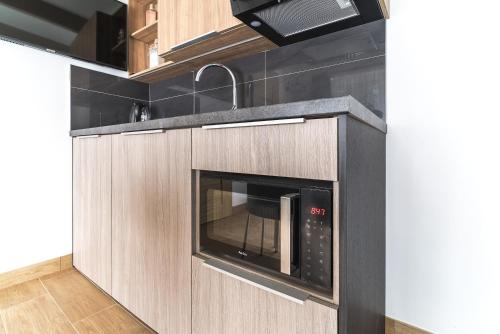 a kitchen with a microwave oven in a kitchen at Nowa Dana Ośrodek Wypoczynkowy in Łebcz
