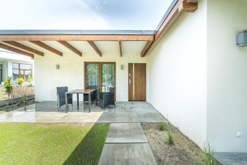 a house with a patio with a table at Nowa Dana Ośrodek Wypoczynkowy in Łebcz