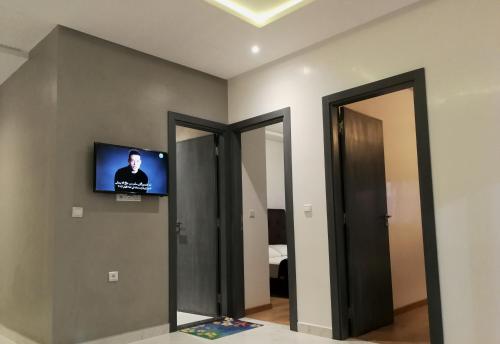 a room with a tv on the wall and a mirror at Crystal Palace Oualidia in Oualidia