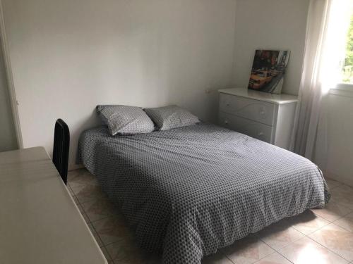 a bedroom with a bed with a black and white comforter at Villa plein pied rez-de-chaussée+1 avec dépendance in Cenon