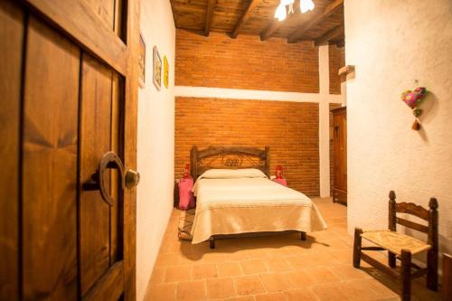 a bedroom with a bed and a brick wall at Hotel Boutique Rincon Sagrado in Atlixco