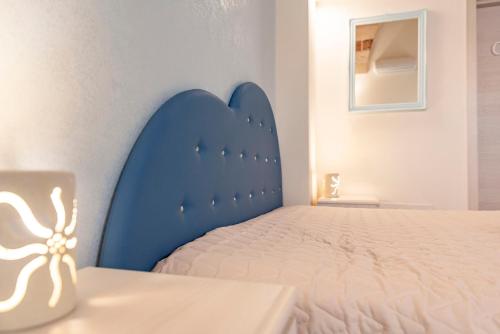 a bed with a blue headboard in a room at B&B Casa di Anita in Arnesano