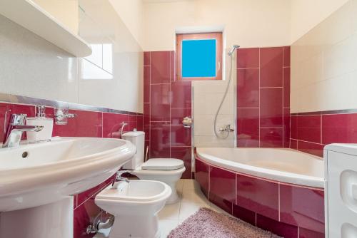 een badkamer met een wastafel, een toilet en een bad bij Apartment Kate's Family Place in Zadar