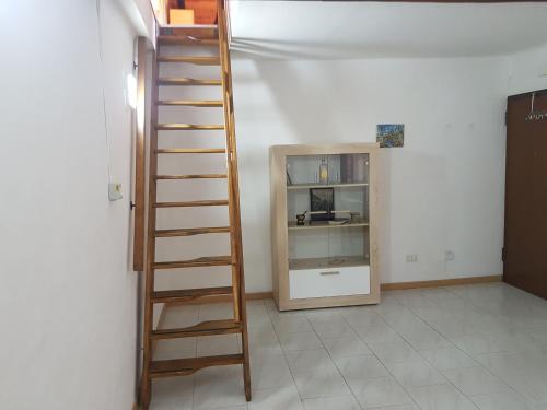 a wooden ladder in a room with a shelf at Sweet Apartment Bianchini in Bologna