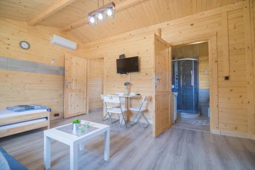 a living room with a table and a tv in a cabin at FamilyCamp in Zator