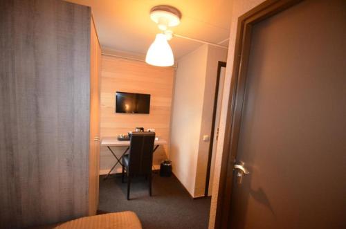 um quarto com uma secretária e uma mesa com luz em Herberg 't Voshoes em Mechelen