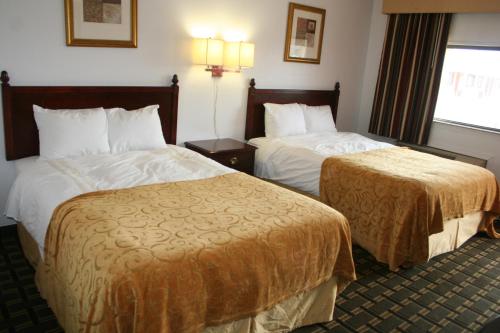 a hotel room with two beds and a window at Scottish Inns Weatherford in Weatherford
