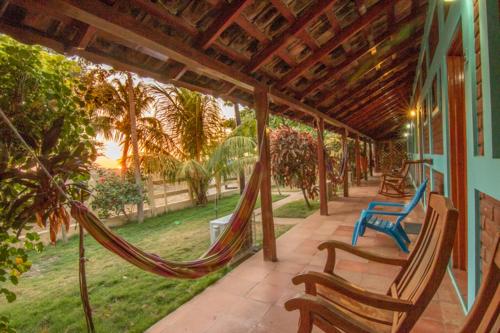 a porch with hammocks and chairs on a house at Club Surf Popoyo in Popoyo