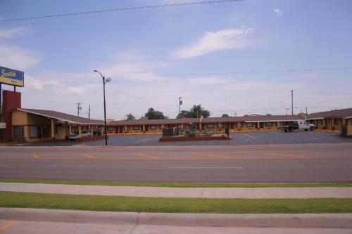 an empty parking lot in front of a motel at Scottish Inns Weatherford in Weatherford