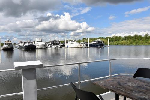 a boat in a marina with boats docked at Cozy floating boatlodge "Maastricht". in Maastricht