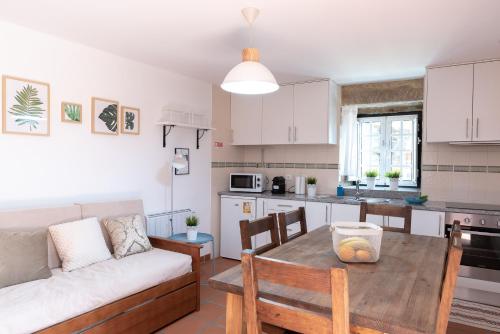 a kitchen and living room with a table and a couch at Casa dos Cortes in Sever do Vouga