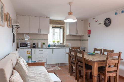 una cucina e un soggiorno con un tavolo e un divano di Casa dos Cortes a Sever do Vouga