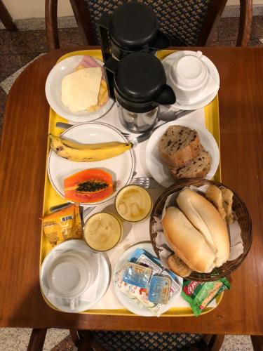 a table with plates of food on top of it at Hotel Sheik (Adults Only) in Rio de Janeiro