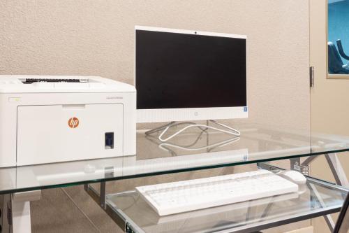 a computer on a glass desk with a keyboard at Sleep Inn Terre Haute University Area in Terre Haute
