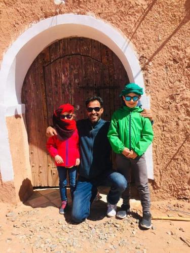 a group of three people standing in front of a door at Tigmi Hamid Découverte des traditions et de la culture berbère in Aït Ben Haddou
