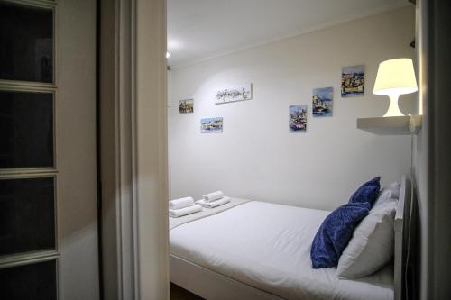 リスボンにあるHistoric Center Apartmentのベッドルーム1室(ランプと壁に絵画付)