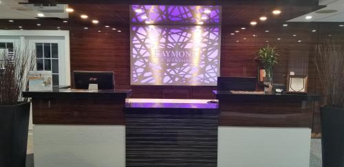 a lobby with a desk with a laptop on it at Baymont by Wyndham Montreal Airport in Dorval