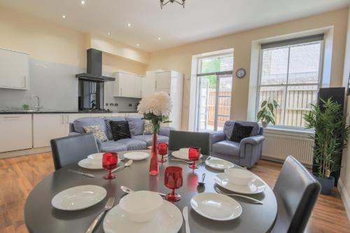 a kitchen and living room with a table and chairs at Stylish Modern 4 Bed Apartment in Edinburgh