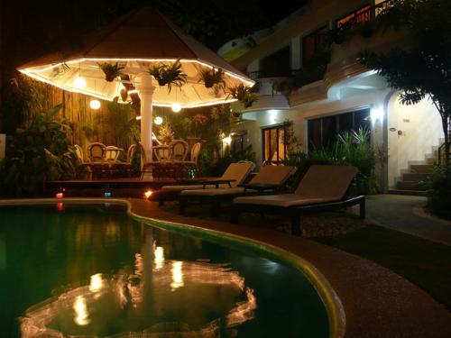 a swimming pool in a yard at night at Villa Sunset Boracay in Boracay