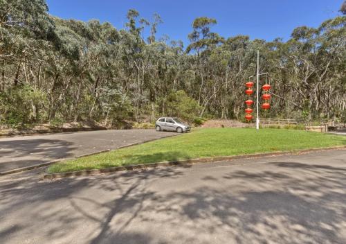 a car driving down a road with red traffic lights at Sinofield Edu-Retreat in Leura