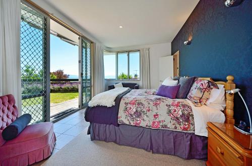 a bedroom with a bed and a large window at Aporo Nelson Holiday Home in Nelson