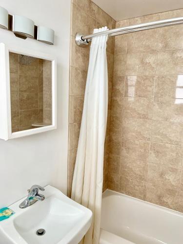 a bathroom with a shower curtain and a sink at White Caps Motel in North Wildwood