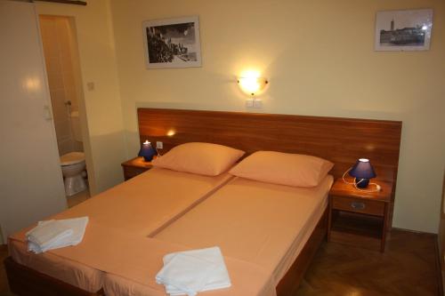 a bedroom with a large bed with two pillows at Apartments Villa Olga in Rab