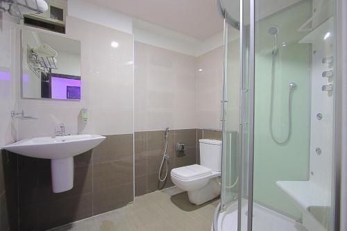 La salle de bains est pourvue de toilettes, d'un lavabo et d'une douche. dans l'établissement ABM Express Inn, à Bangalore