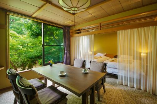 a room with a table and a bedroom with a bed at Matsusaki in Nomi