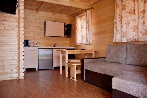 a living room with a couch and a table and a kitchen at OW Gabi in Międzywodzie