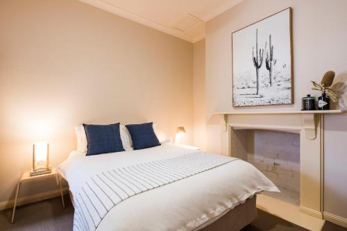 a bedroom with a large bed and a fireplace at Peppertree Terraces in Mudgee