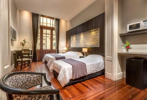 ein Hotelzimmer mit 2 Betten und einem Schreibtisch in der Unterkunft Up Tribeca in Buenos Aires