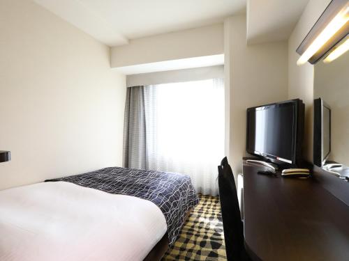 東京にあるアパホテル〈新橋 御成門〉のベッド1台、薄型テレビが備わるホテルルームです。
