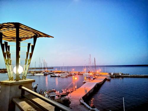 a dock with boats in the water at night at Marina City ApartHotel in Balchik