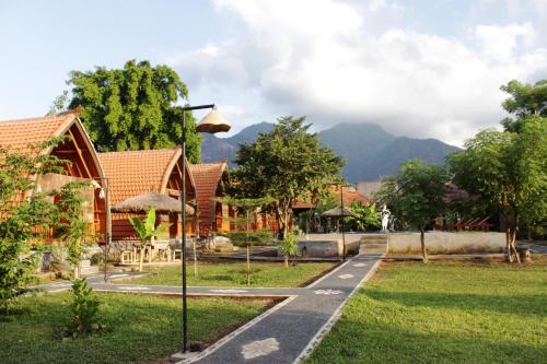 a view of a resort with mountains in the background at Kubu Padi Wooden House in Pemuteran