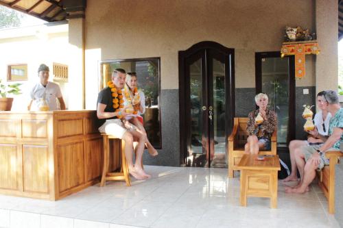 a group of people sitting at a bar at Kubu Padi Wooden House in Pemuteran